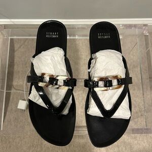 Stuart Weitzman, black patent leather sandals with tortoise buckle.